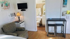 A compact hotel room with a bed, a small desk with a lamp, a television, and a view of the bathroom. - Two double bed studio with full kitchen on 2nd floor . (Pompano Beach)