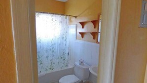 Une salle de bain avec des toilettes, un lavabo et un rideau de douche.