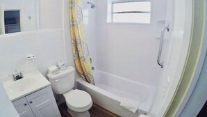 A bathroom with a toilet, sink, and shower area. - Cozy Queen Studio with Kitchen and Scenic Beach Views (Pompano Beach)