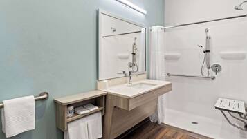 A modern bathroom with a sink, mirror, and shower.