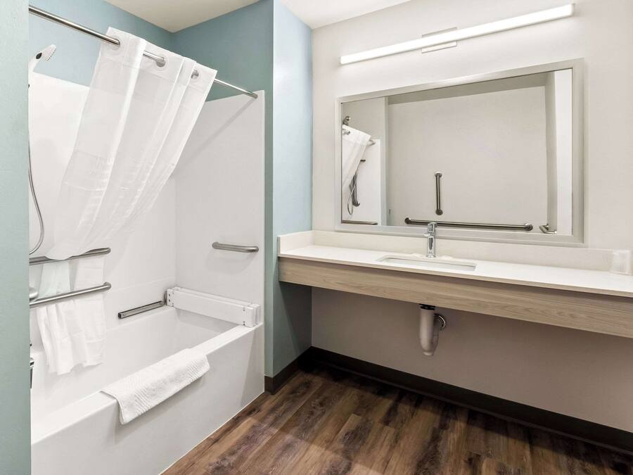 A modern bathroom with a shower, a sink, and a mirror.