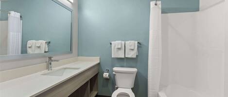 A modern bathroom with a white sink, a toilet, and a shower curtain.
