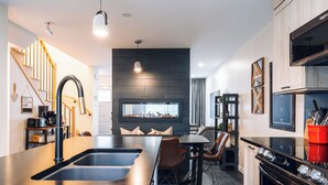 Eine moderne Küche mit Kochinsel, integriertem Backofen und einem Essbereich mit Sofa und Stühlen.
