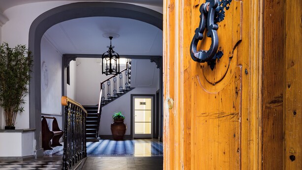 A grand hallway with a checkered floor, a staircase, and a wooden door with a metal handle. - "AL PALAZZO" - Pergola Suite - 500m from the Duomo (firenze)