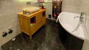 Ein modernes Badezimmer mit einer freistehenden Badewanne, einem Waschtisch mit Spiegel und einem großen Wandbild.