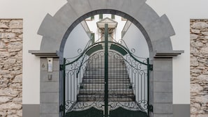 A wrought iron gate with a stone wall backdrop.