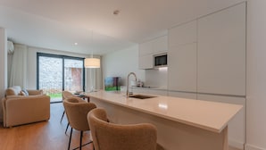 A modern kitchen with a large island, a dining area with chairs, and a sofa.