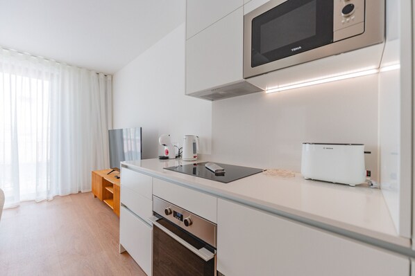A modern kitchen with a microwave, toaster, and oven.
