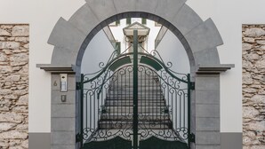 A wrought iron gate with a stone wall backdrop.