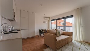 Eine moderne Wohnung mit Küche, Essbereich und Wohnzimmer mit Sofa.