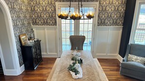 A dining area with a wooden table, grey upholstered chairs, and a decorative centerpiece. - Lakeside Valley Vineyards B&B (Jasper)