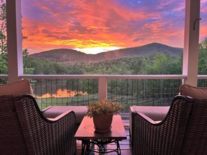 A balcony with wicker furniture, a table, and a potted plant. - Lakeside Valley Vineyards B&B (Jasper)