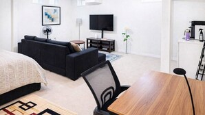 Une chambre d’hôtel moderne équipée d’un canapé, d’une télévision, d’une table à manger et d’un lit.