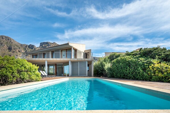 A modern house with a swimming pool, surrounded by greenery and mountains in the background. - Chiroy, Villa 5StarsHome Mallorca (Arta)