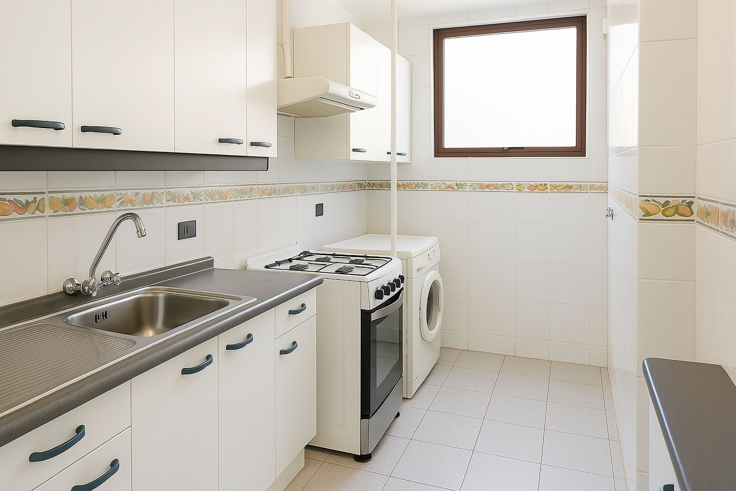 Cozinha compacta com pia, fogão e máquina de lavar.