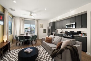 Un salon moderne avec un canapé, une table basse et un coin repas.