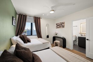Een hotelkamer met een bed, een bureau, een spiegel en uitzicht op de stad.