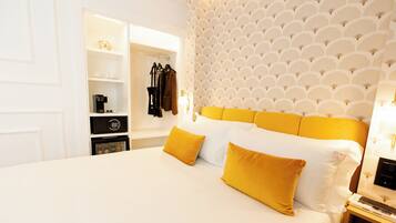 A hotel room with a large bed, a wardrobe, a bedside table, and a patterned wall.