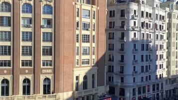 A multi-story hotel with a prominent arched entrance and a balcony on the upper floors.