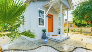 Uma pequena casa com varanda, porta e janela.