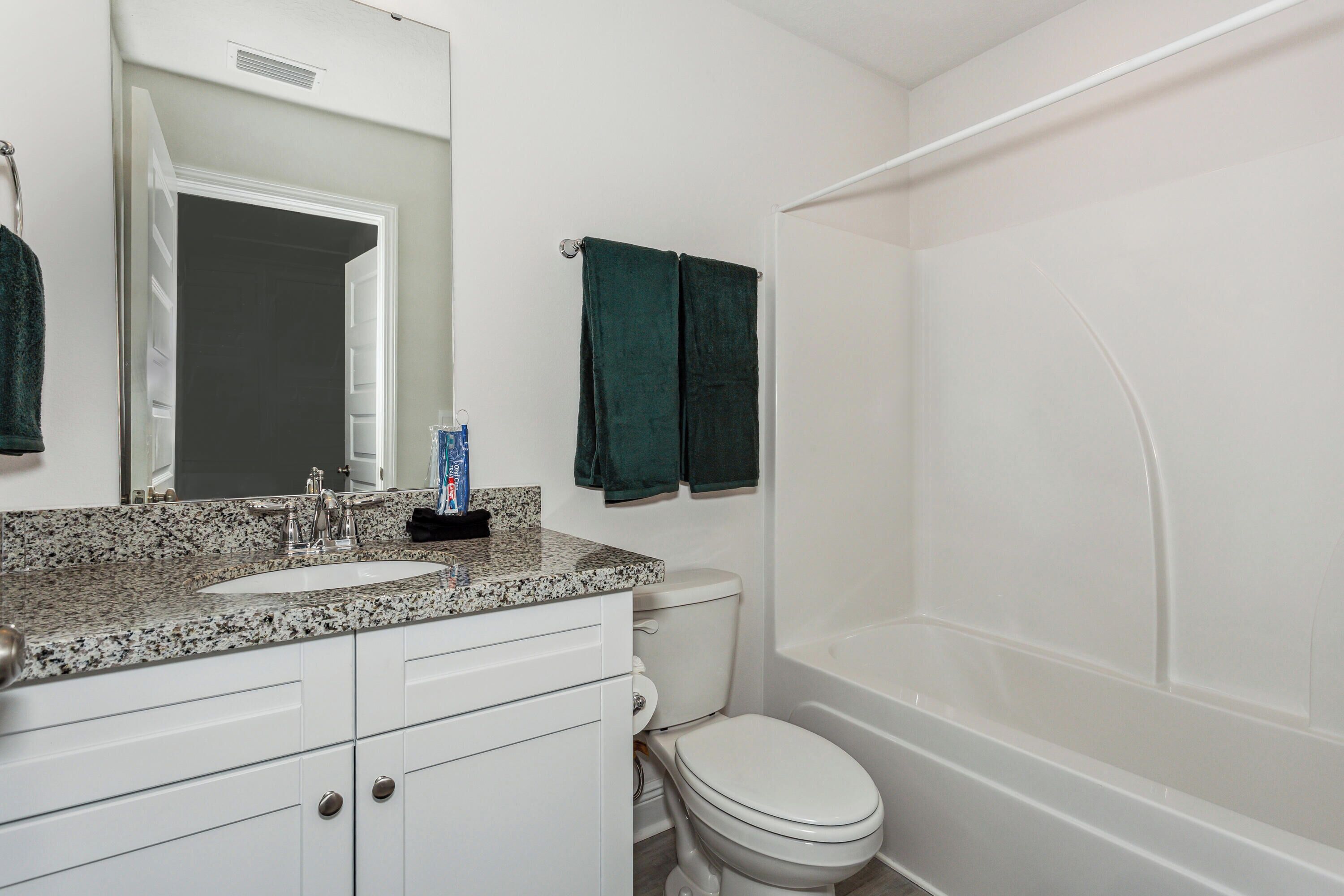 A bathroom with a white sink, a toilet, and a bathtub.