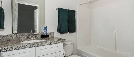 A bathroom with a white sink, a toilet, and a bathtub.