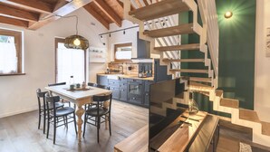 Una cocina moderna con vigas de madera, un comedor con mesa y sillas de madera, y una escalera de diseño único.
