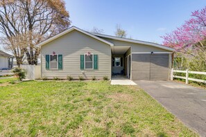 A single-story house with a garage, a front yard, and a tree with pink blossoms. - Potomac River Getaway: Walk to Marina! (King George)