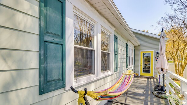 A porch with a hammock, a yellow door, and a white fence. - Potomac River Getaway: Walk to Marina! (King George)