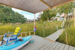 A wooden dock leading to a body of water with a kayak and a chair with a life jacket. - Potomac River Getaway: Walk to Marina! (King George)