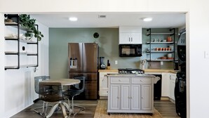Une cuisine compacte avec un coin repas comprenant une table, des chaises et un four à micro-ondes.