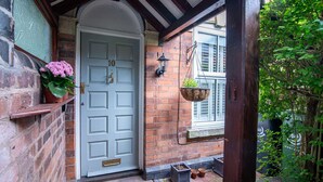 A white door with the number 10, a hanging lantern, and potted plants on the porch. - Host Stay Terrace on Canal (Worcester)