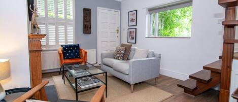 A living room with a sofa, coffee table, and a staircase.