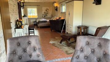 A spacious living area with a fireplace, a bed, and a dining area.
