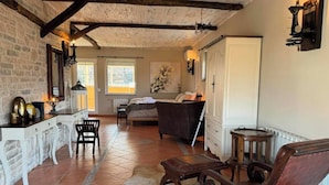 Ein gemütliches Zimmer mit einem Bett, einem Schreibtisch und einem Stuhl. Es gibt ein Fenster und eine Tür.