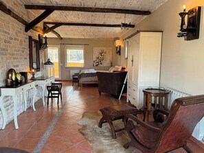 Ein gemütliches Zimmer mit einem Bett, einem Schreibtisch und einem Stuhl. Es gibt ein Fenster und eine Tür.