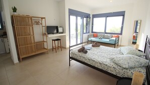 Un dormitorio con cama, escritorio y armario.