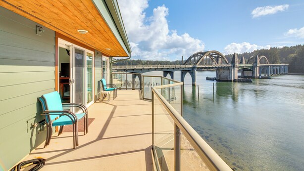 A balcony with chairs and a view of a bridge over water. - Riverfront Apt in Old Town Florence! (Florence)