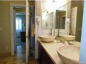 A bathroom with two large sinks, a mirror, and a towel hanging on the wall.