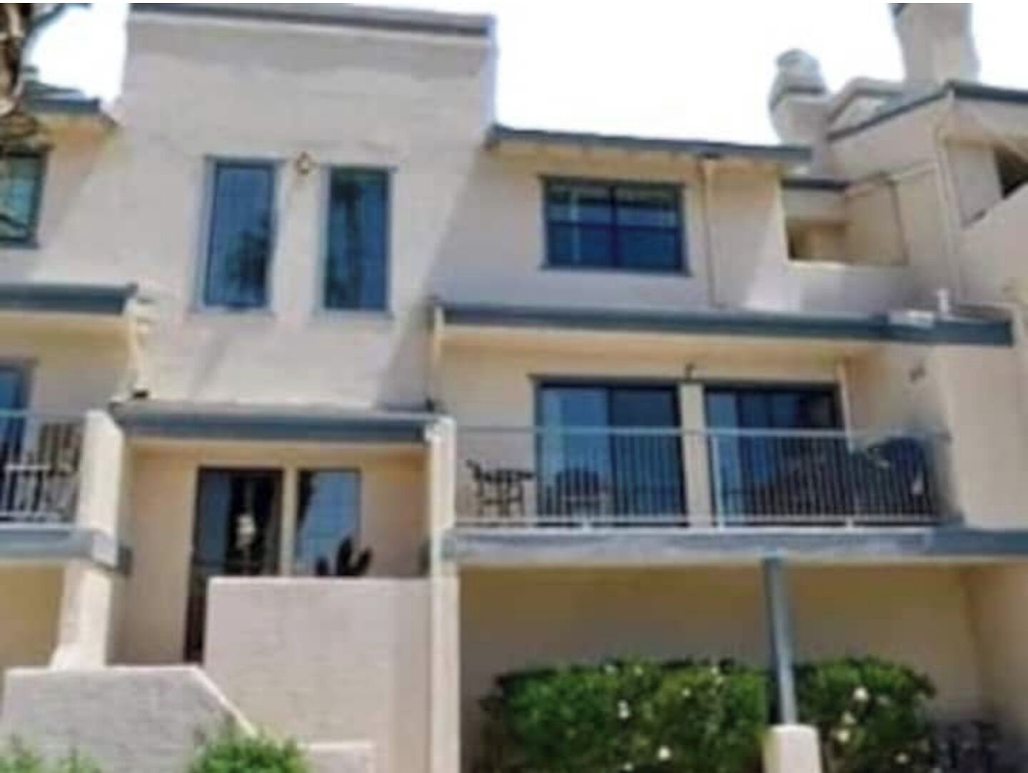 Un edificio residencial de varios pisos con balcones, techo plano y fachada uniforme.