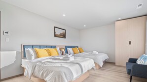 A modern hotel room with two beds, a wardrobe, and a seating area. - 3-bedroom house on 2F in peaceful Daly City with AC, WiFi. (Daly City)