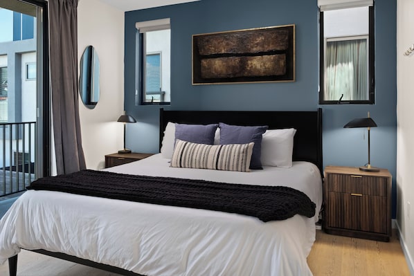 Una camera da letto con un letto, due comodini, uno specchio e una finestra.