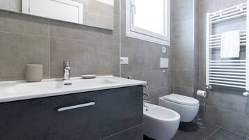 Regadera, secadora de cabello, bidet, toallas