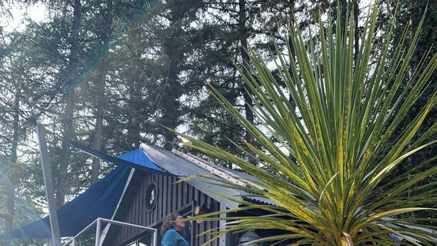 A stone statue, a wooden structure, and a person on a staircase. - Luxury Lodge Palms 3 with hot tub - Accessible Access (North Connel)