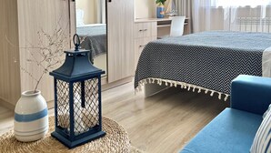 Um quarto moderno com uma cama, uma escrivaninha, uma cadeira, um guarda-roupa, um espelho e uma janela com cortinas.