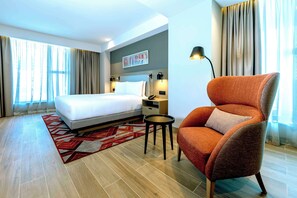 A hotel room with a bed, a nightstand, a chair, and a painting on the wall. - Hyatt House Nairobi Westlands (Nairobi)