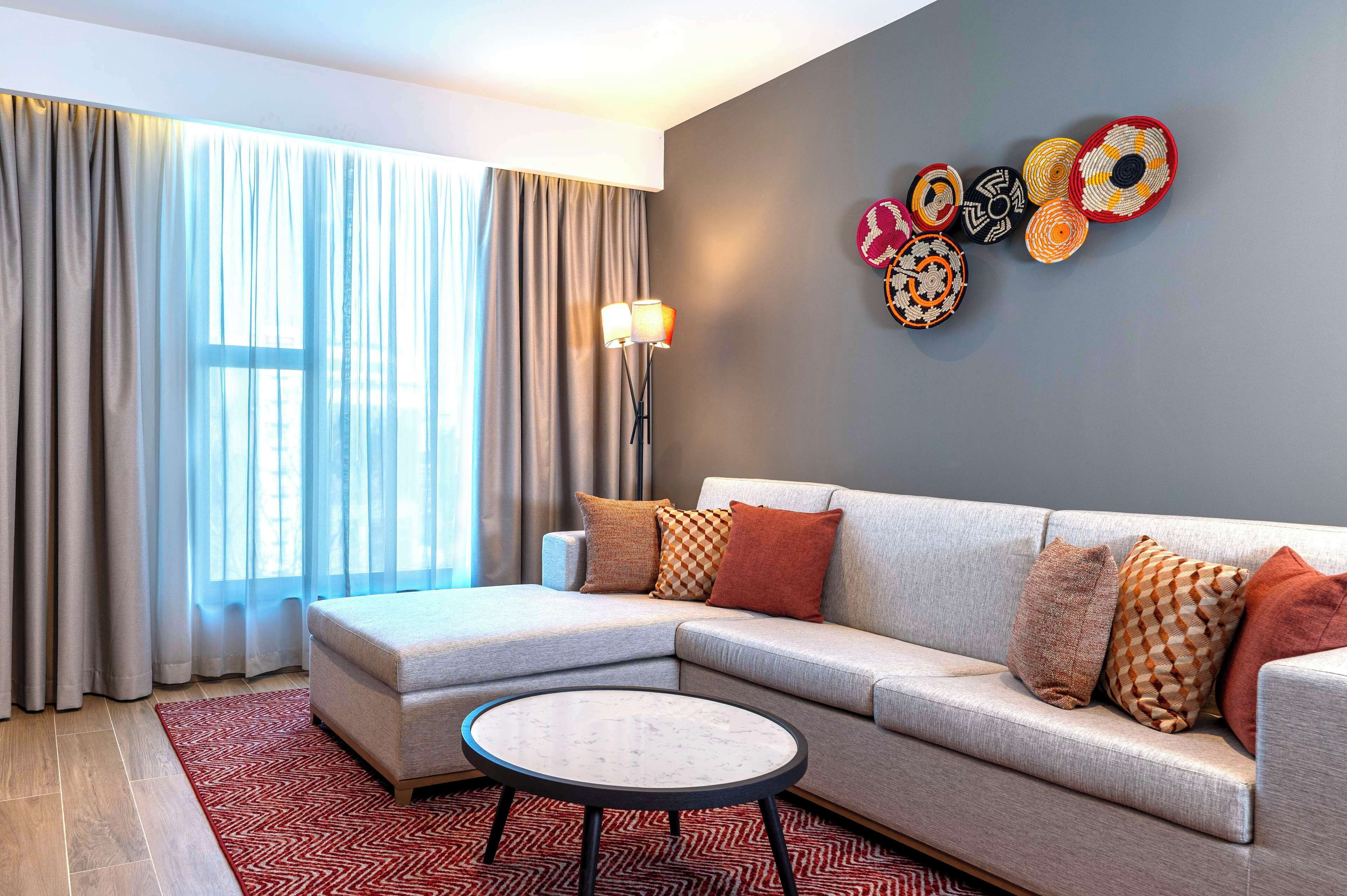 A modern living room with a sectional sofa, a round coffee table, and a floor lamp.