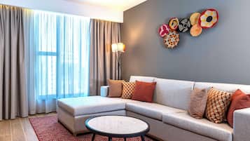 A modern living room with a sectional sofa, a round coffee table, and a floor lamp.