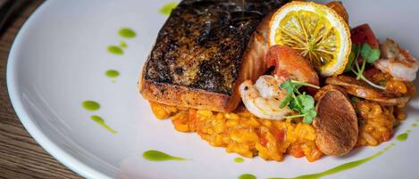 A plate of food with a grilled steak, shrimp, and vegetables.