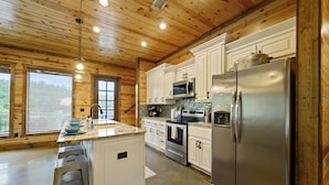 A modern kitchen with white cabinets, stainless steel appliances, and a granite countertop.
